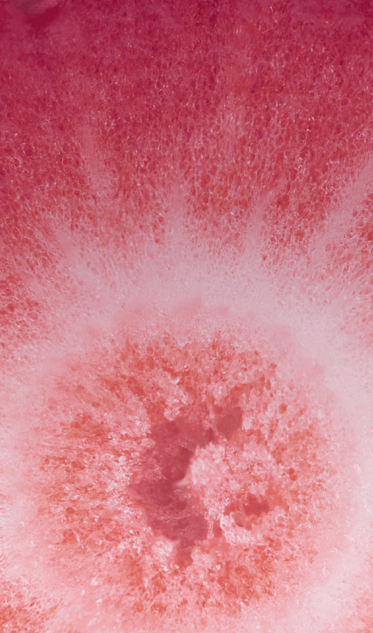 Behind the Berry Medley flavor bottle there’s a macro image of a bright pink and red berry.