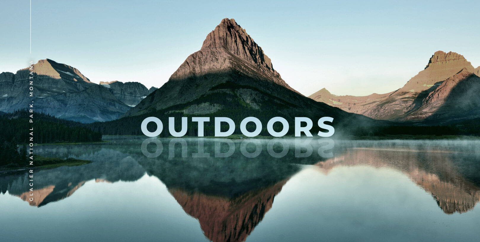 A large mountain within Glacier National Park is pictured with a reflective body of water sitting in front of it. The word “OUTDOORS” for desktop browsers