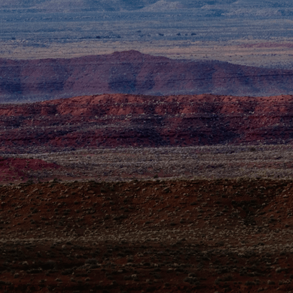 Behind a Trail Mix protein bar, a mountain range is pictured which has been treated with a blue-ish color.